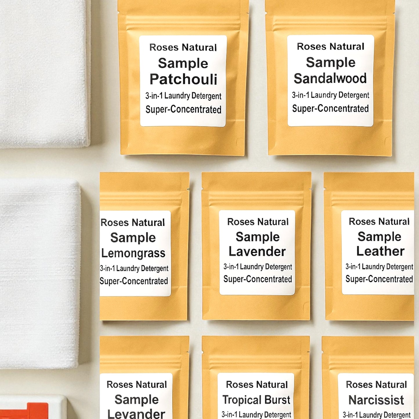 Gold sample packages of Roses Natural laundry detergent with labels on a white background