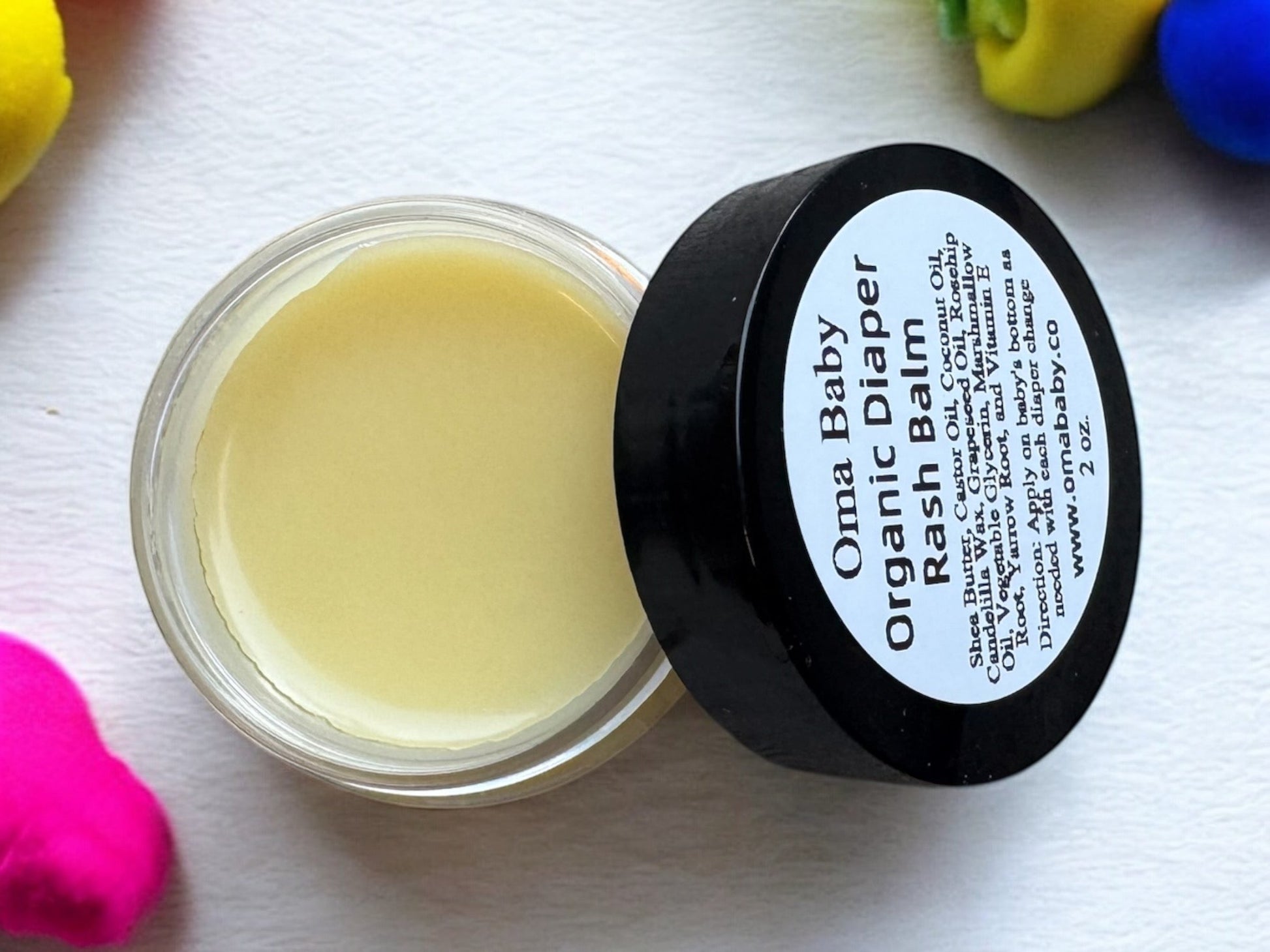 Oma Baby Organic Diaper Rash Balm jar with black lid on a white background