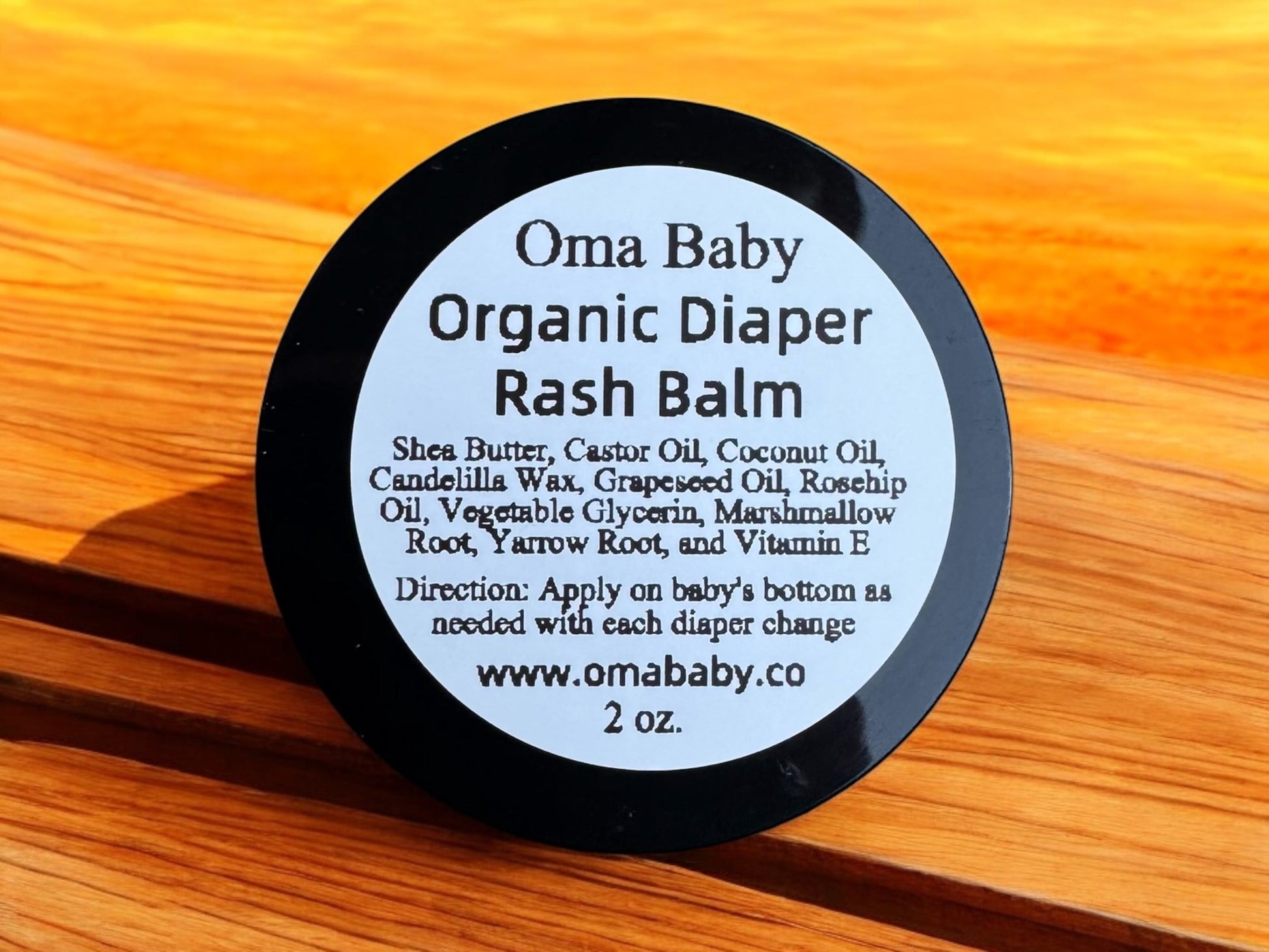 Oma Baby Organic Diaper Rash Balm container on a wooden surface