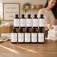 Set of plant-based laundry products on a wooden shelf with a woman in a neutral sweater.