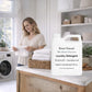 Woman in a laundry room with a bottle of Roses Natural laundry detergent. Patchouli and Sandalwood scent 