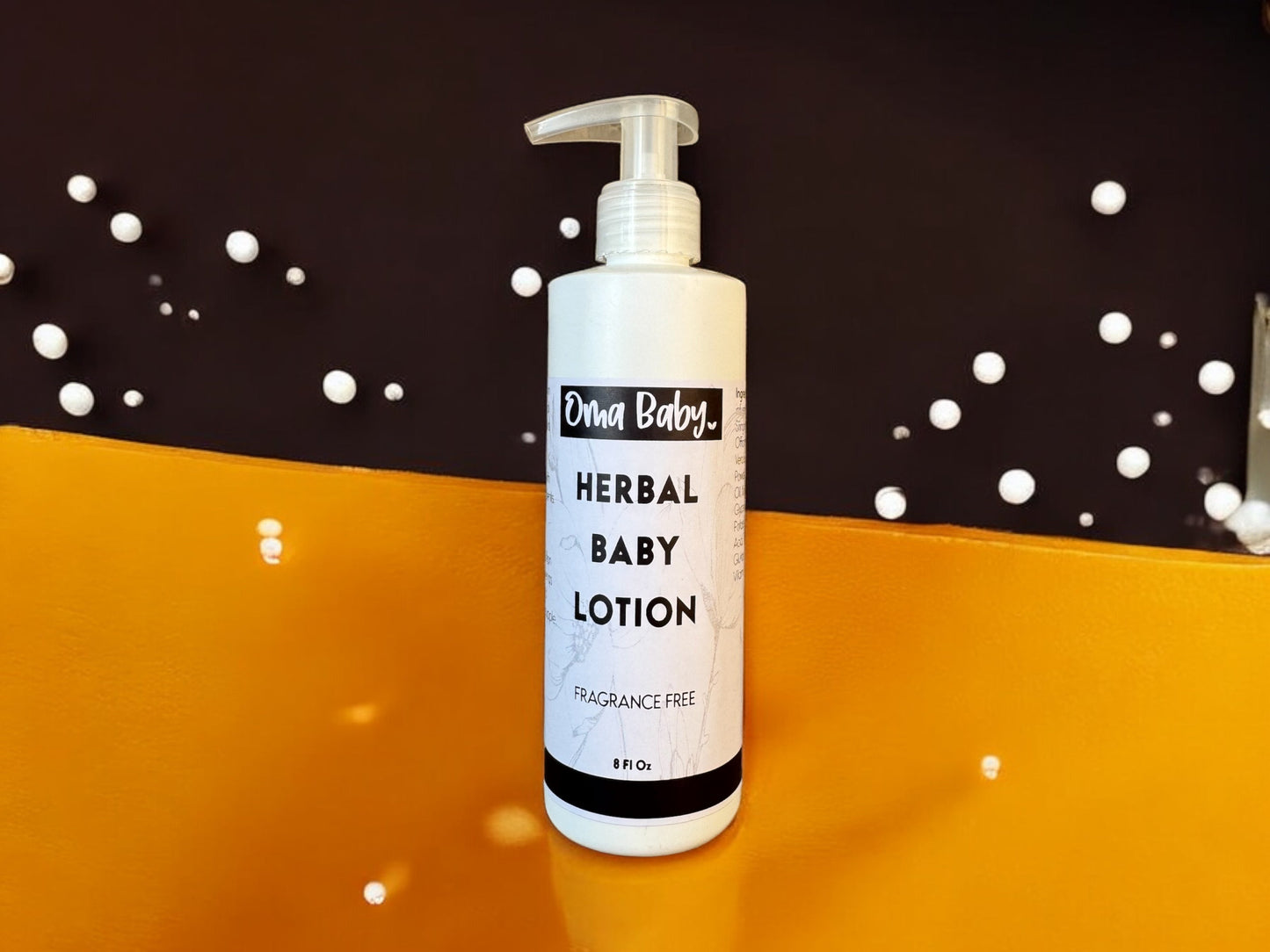 Bottle of Oma Baby Herbal Baby Lotion on a reflective surface with a dark background