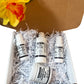 Four skincare products in a box with shredded paper and a yellow flower in the background