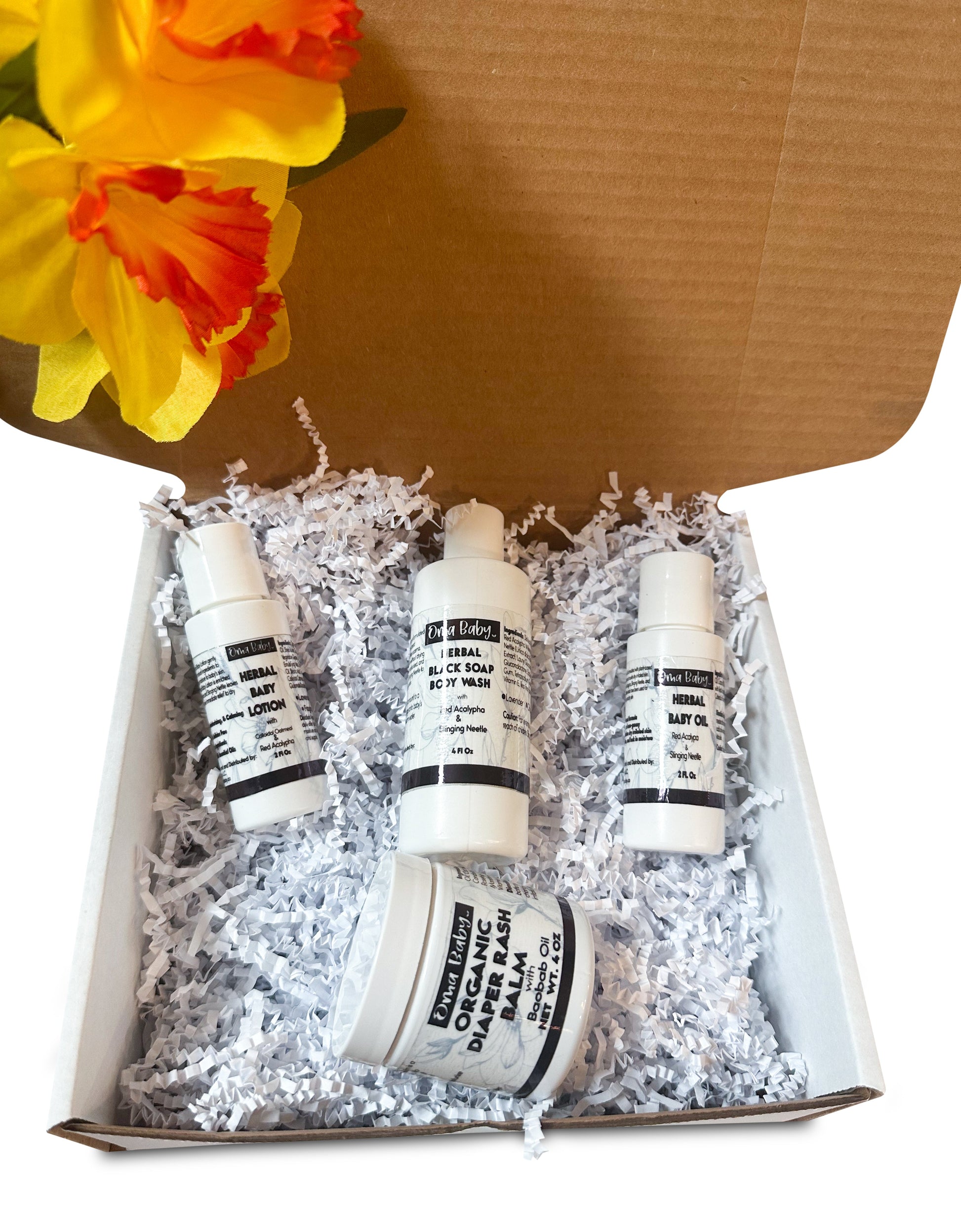 Four skincare products in a box with shredded paper and a yellow flower in the background