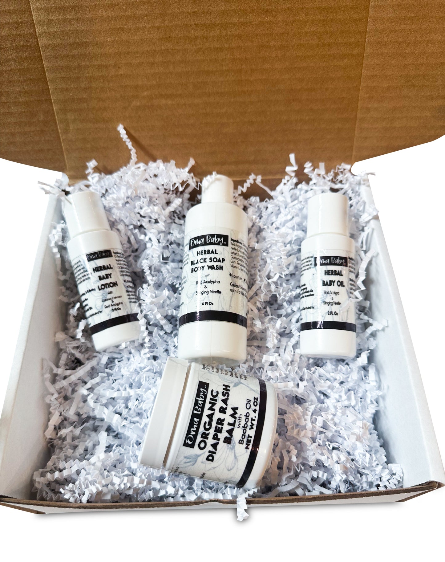 Four bottles of organic baby products in a box with white crinkle paper